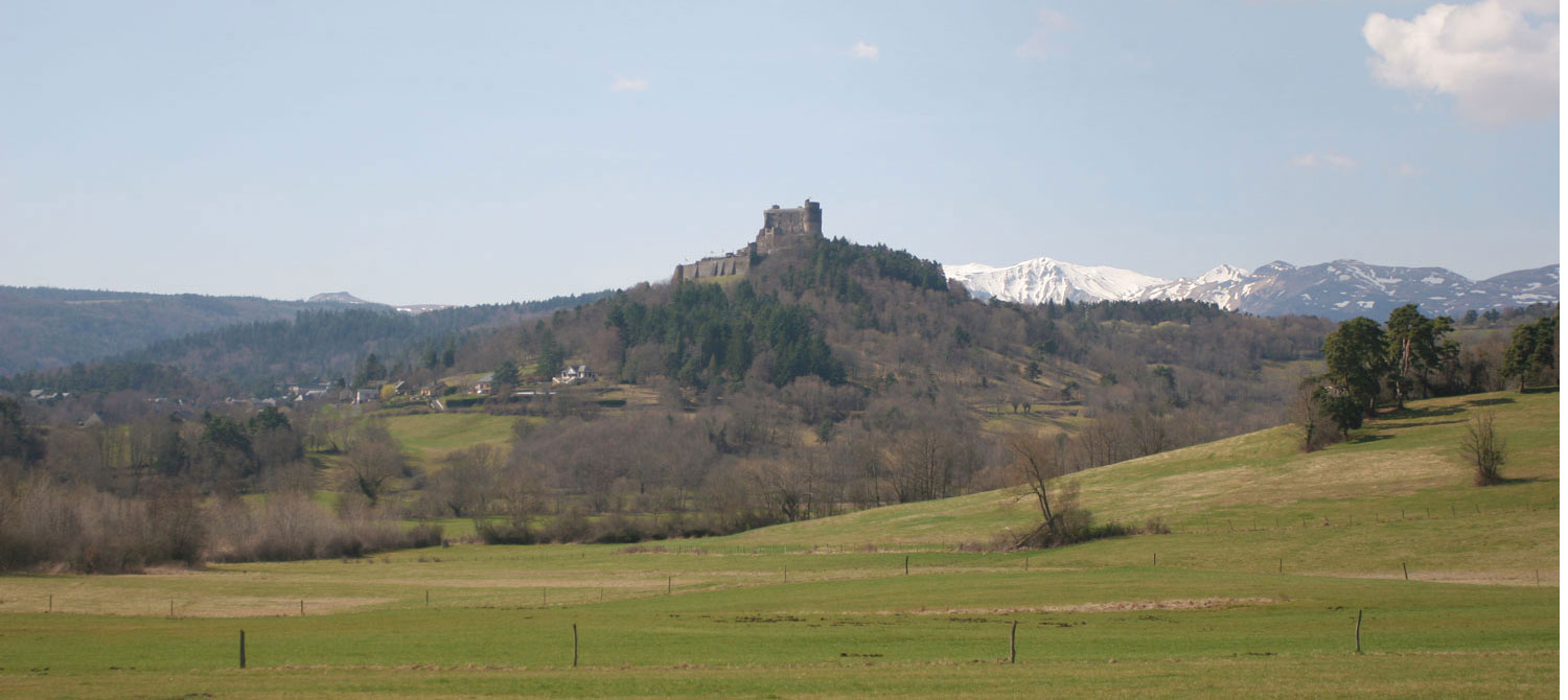 Château de Murat et massif du Sancy enneigé au fond