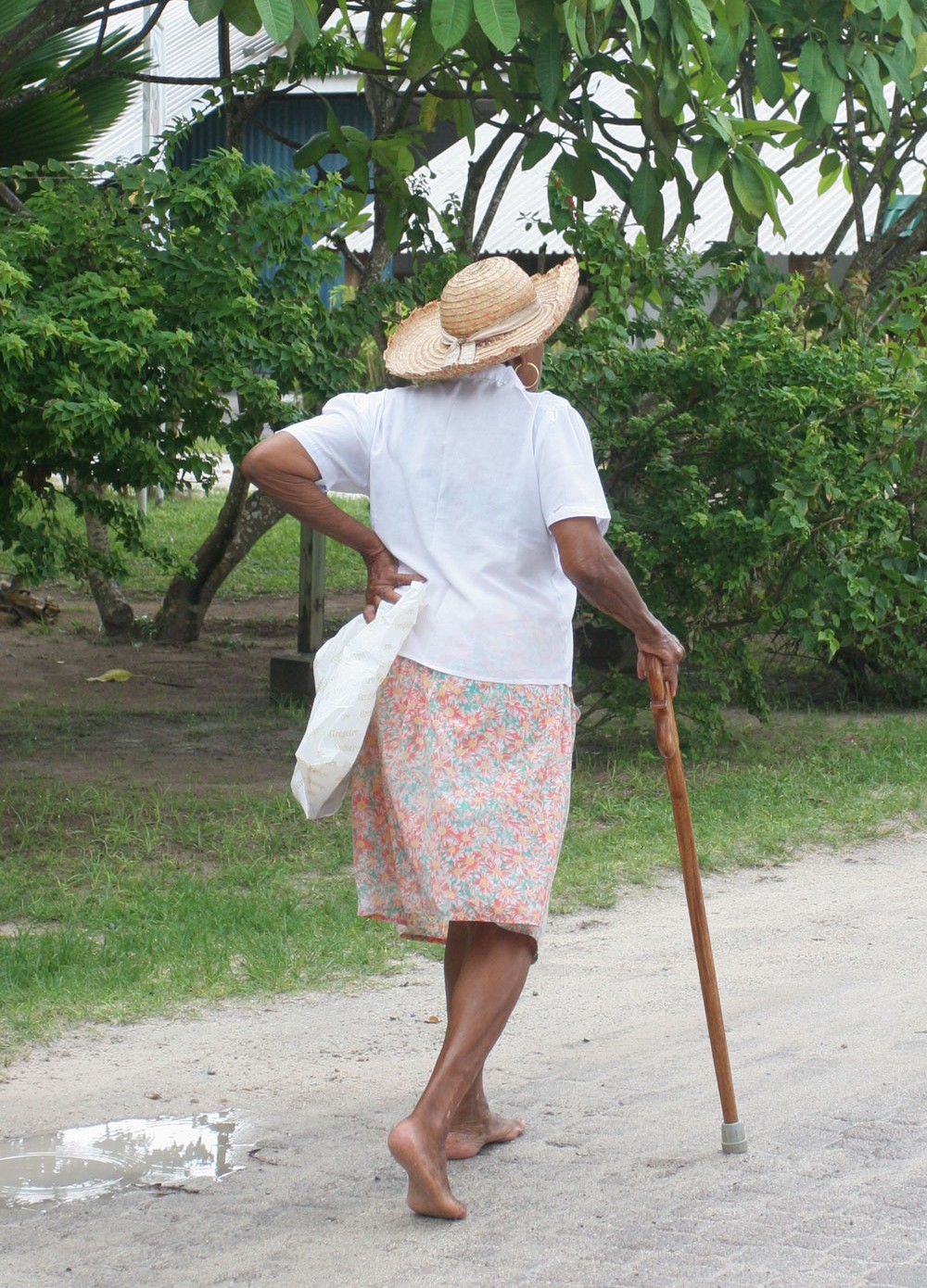 Dame âgée marchant à La Passe, île de La Digue (Seychelles)